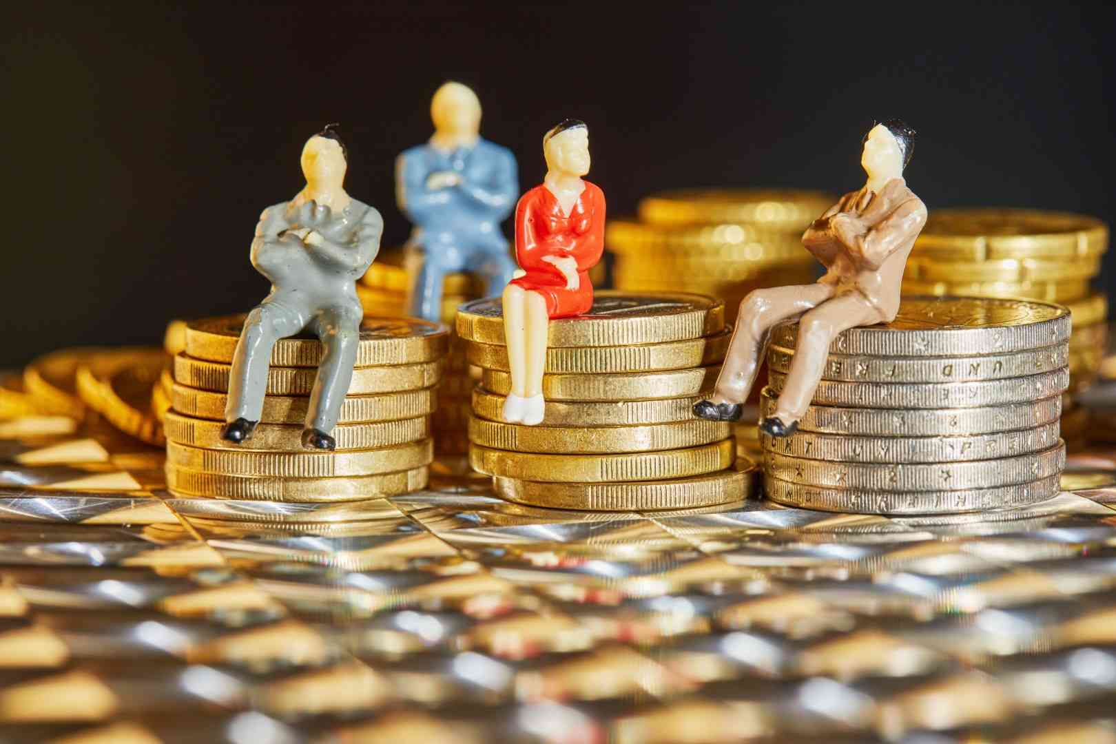 multiple people sitting on coin stack representing joint contribution
